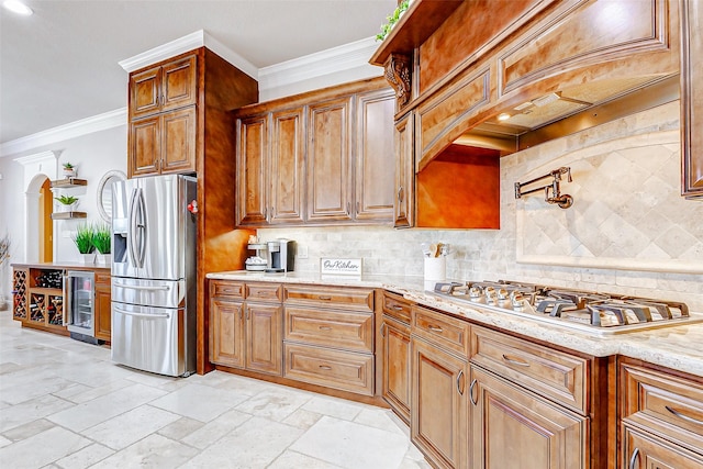 32811 Warbler Ct, Fulshear, TX 77441 - kitchen with appliances with stainless steel finishes, wine cooler, backsplash, brown cabinets, and crown molding