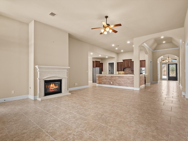 4410 Cobalt Cross St, Katy, TX 77493 - unfurnished living room featuring a glass covered fireplace, recessed lighting, arched walkways, a ceiling fan, and baseboards