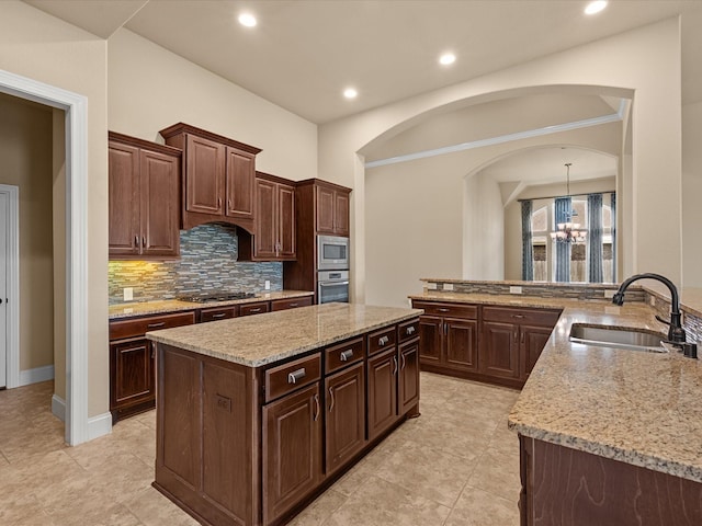 4410 Cobalt Cross St, Katy, TX 77493 - kitchen featuring stainless steel appliances, a sink, backsplash, a kitchen island, and light stone counters