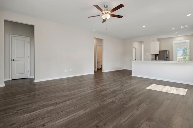 unfurnished living room featuring dark wood finished floors, a ceiling fan, baseboards, and recessed lighting
