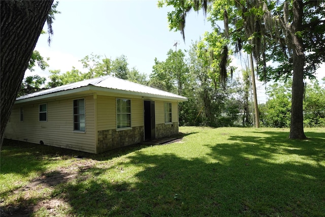 215 Weldon, Livingston, TX 77351 - view of home's exterior featuring stone siding, a lawn, and metal roof