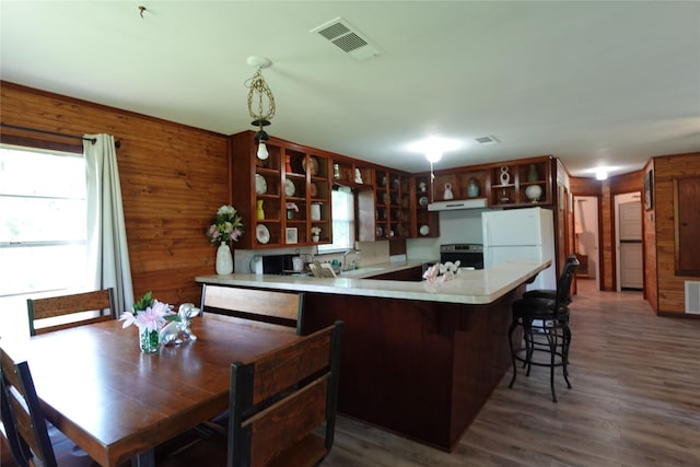 215 Weldon, Livingston, TX 77351 - kitchen with open shelves, freestanding refrigerator, under cabinet range hood, wood finished floors, and a peninsula