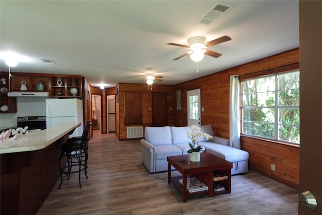 215 Weldon, Livingston, TX 77351 - living room with a ceiling fan, wood finished floors, and wooden walls
