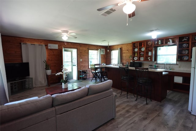 215 Weldon, Livingston, TX 77351 - living area featuring ceiling fan, light wood-style floors, and wood walls