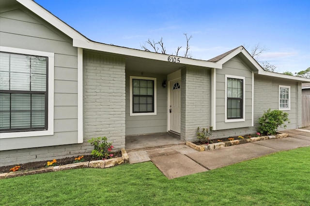 6105 Arthington St, Houston, TX 77053 - doorway to property featuring brick siding and a lawn