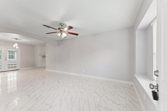 6105 Arthington St, Houston, TX 77053 - spare room with a ceiling fan, light marble finish floors, baseboards, and arched walkways