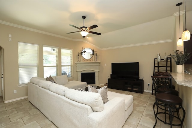living room featuring ceiling fan, a tiled fireplace, crown molding, vaulted ceiling, and light tile patterned floors