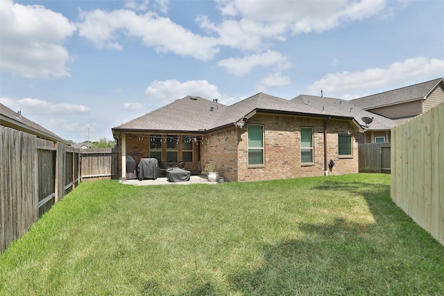 rear view of house with brick siding, a patio, and roof with shingles