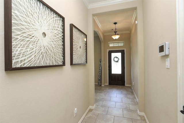 doorway with arched walkways, baseboards, tile patterned flooring, and crown molding