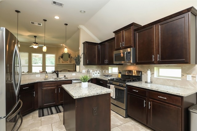 kitchen with appliances with stainless steel finishes, ornamental molding, a sink, ceiling fan, and decorative backsplash