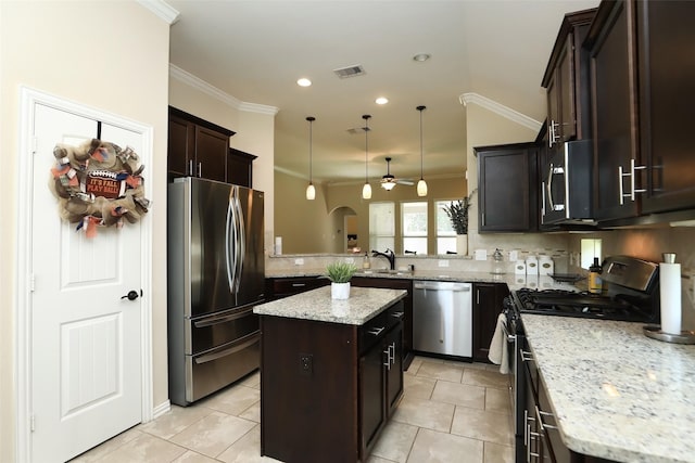 kitchen with stainless steel appliances, ornamental molding, backsplash, dark brown cabinetry, and a kitchen island