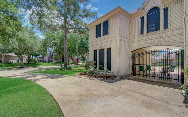 10711 Sea Myrtle Dr, Houston, TX 77095 - view of side of property featuring brick siding, a lawn, and a gate