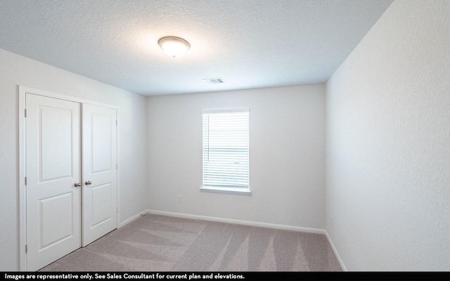 2443 Solaris Bend Dr, Katy, TX 77493 - unfurnished room with light colored carpet, baseboards, and a textured ceiling
