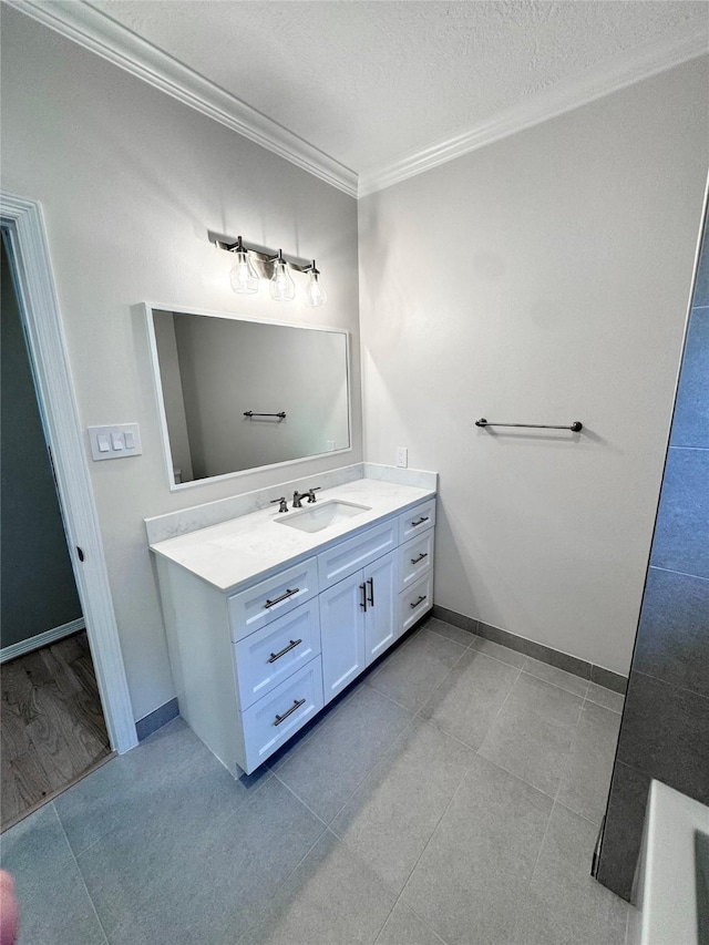 full bath with crown molding, vanity, baseboards, a textured ceiling, and tile patterned flooring