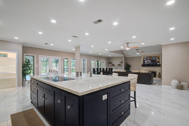 2616 Ryder Ct, League City, TX 77573 - kitchen with black electric stovetop, a breakfast bar area, crown molding, recessed lighting, and a kitchen island