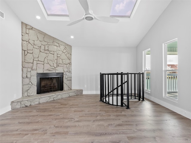 1322 Oahu Dr, Tiki Island, TX 77554 - unfurnished living room featuring a skylight, wood finished floors, ceiling fan, a fireplace, and recessed lighting