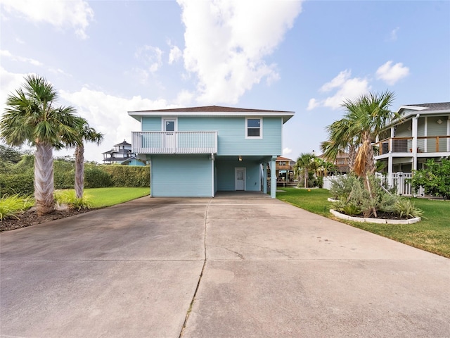 1322 Oahu Dr, Tiki Island, TX 77554 - view of front facade featuring a carport, concrete driveway, and a front yard