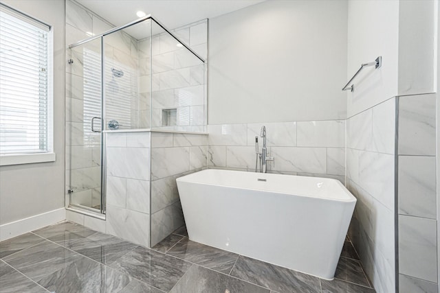622 Janisch Rd Unit A, Houston, TX 77018 - bathroom with marble tiled floors, a stall shower, a freestanding tub, tile walls, and baseboards