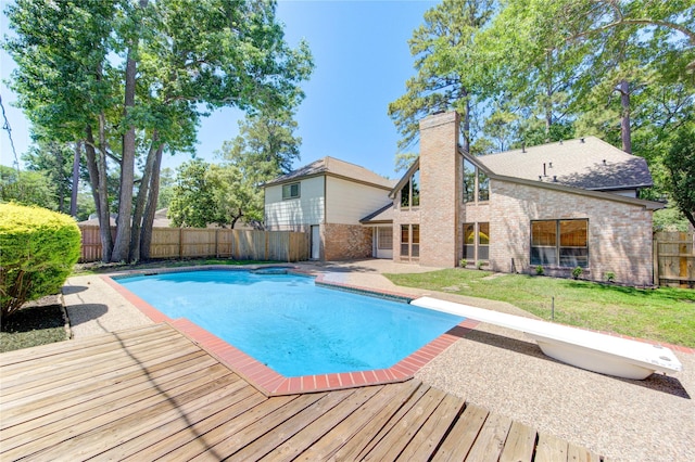 view of pool with a diving board and a wooden deck