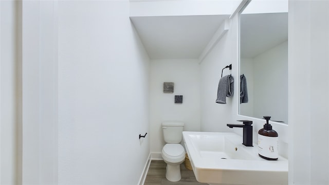 3019 Jensen Springs Ln, Houston, TX 77026 - half bath with toilet, wood finished floors, baseboards, and a sink