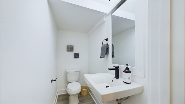 3019 Jensen Springs Ln, Houston, TX 77026 - half bath with wood finished floors, toilet, a sink, and baseboards