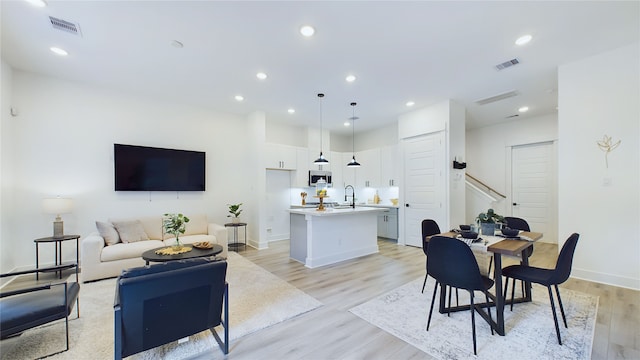 3019 Jensen Springs Ln, Houston, TX 77026 - living room featuring light wood-type flooring, recessed lighting, baseboards, and stairs