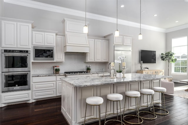 831 Dunleigh Meadows Ln, Houston, TX 77055 - kitchen with built in appliances, dark wood finished floors, a breakfast bar, white cabinetry, and recessed lighting