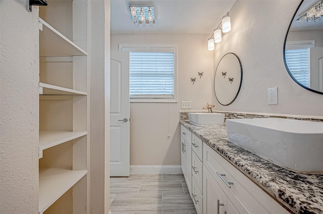 bathroom with double vanity and baseboards