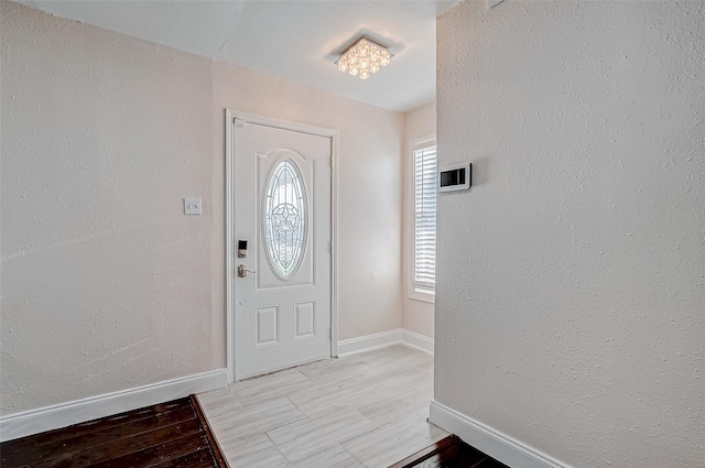 entrance foyer with baseboards and light wood-style floors