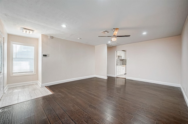 spare room with a ceiling fan, dark wood finished floors, baseboards, and recessed lighting