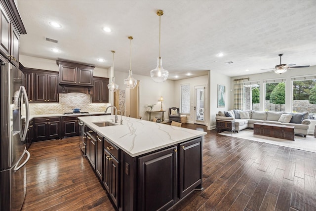 5119 Kendalia Cloud Ln, Fulshear, TX 77441 - kitchen with a sink, stainless steel refrigerator with ice dispenser, open floor plan, a ceiling fan, and backsplash