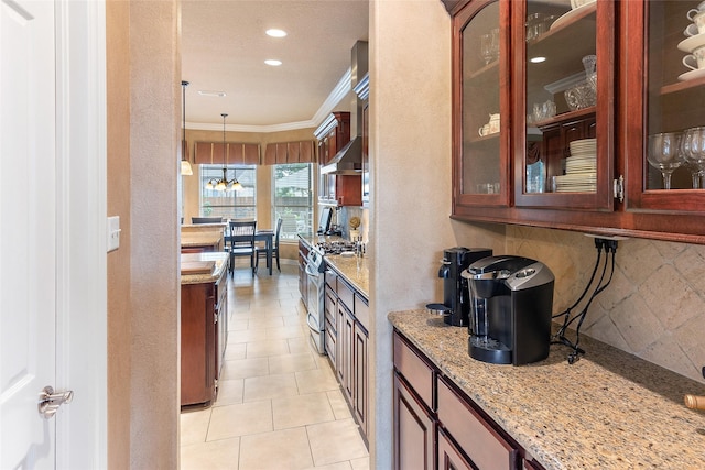 208 Canyon Oak Dr, Lake Jackson, TX 77566 - kitchen featuring stainless steel gas range oven, tasteful backsplash, crown molding, light stone countertops, and a chandelier