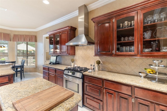 208 Canyon Oak Dr, Lake Jackson, TX 77566 - kitchen with stainless steel gas stove, wall chimney range hood, crown molding, light tile patterned floors, and decorative backsplash
