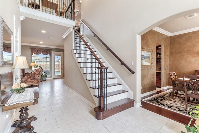 208 Canyon Oak Dr, Lake Jackson, TX 77566 - stairs featuring ornamental molding, tile patterned floors, arched walkways, baseboards, and a towering ceiling
