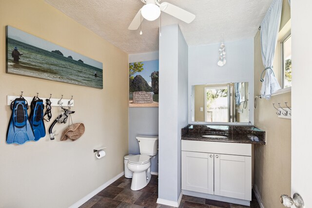 7719 Allegro Dr, Houston, TX 77040 - bathroom with baseboards, toilet, a ceiling fan, a textured ceiling, and vanity