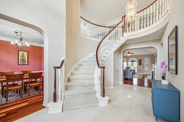 7719 Allegro Dr, Houston, TX 77040 - entryway featuring a chandelier, arched walkways, stairway, a high ceiling, and baseboards