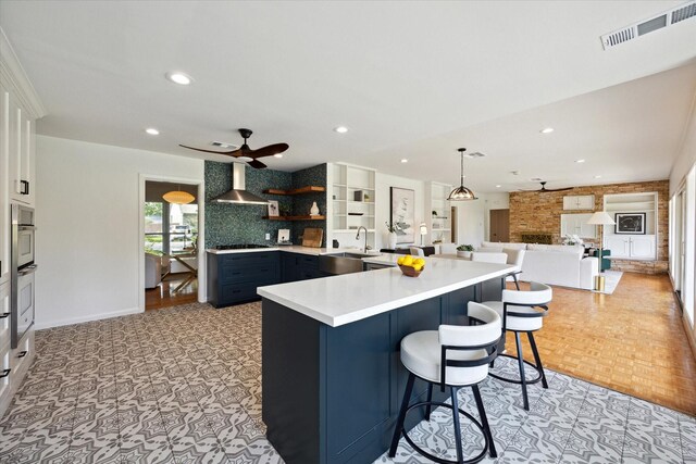 1415 Lehman St, Houston, TX 77018 - kitchen with wall chimney exhaust hood, open shelves, light countertops, a breakfast bar area, and recessed lighting