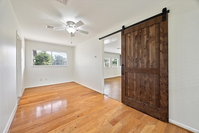 1415 Lehman St, Houston, TX 77018 - spare room with a barn door, ceiling fan, wood finished floors, and baseboards