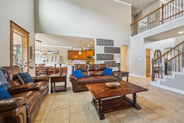 802 Fairway Dr, La Porte, TX 77571 - living room with a towering ceiling, light tile patterned flooring, stairway, arched walkways, and baseboards