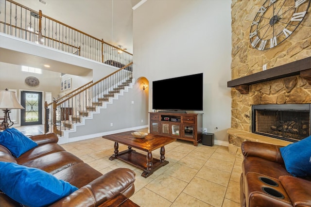 802 Fairway Dr, La Porte, TX 77571 - tiled living room featuring a high ceiling, stairway, baseboards, and a stone fireplace