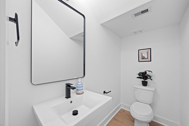 320 Neyland St, Houston, TX 77022 - bathroom featuring a sink, wood finished floors, baseboards, and toilet