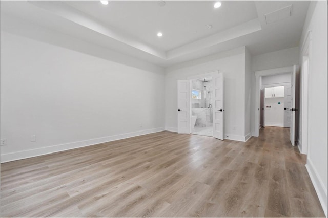 5518 Cortlandt St Unit A, Houston, TX 77076 - unfurnished bedroom with a raised ceiling, light wood-style floors, ensuite bathroom, baseboards, and recessed lighting