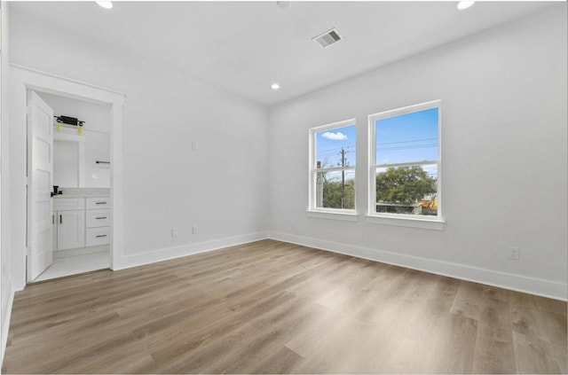 5518 Cortlandt St Unit A, Houston, TX 77076 - unfurnished bedroom featuring light wood finished floors, baseboards, recessed lighting, and ensuite bathroom