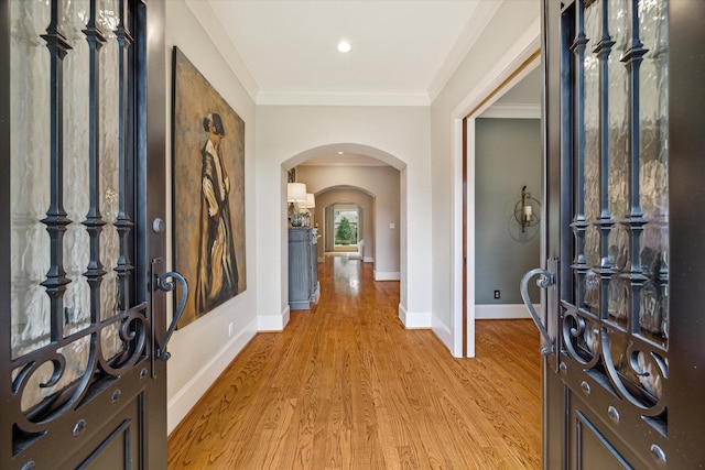 4504 Birch St, Bellaire, TX 77401 - foyer featuring arched walkways, light wood-type flooring, crown molding, and baseboards