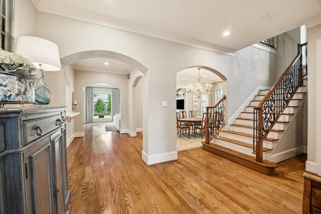 4504 Birch St, Bellaire, TX 77401 - entryway with arched walkways, light wood-style floors, ornamental molding, stairs, and baseboards