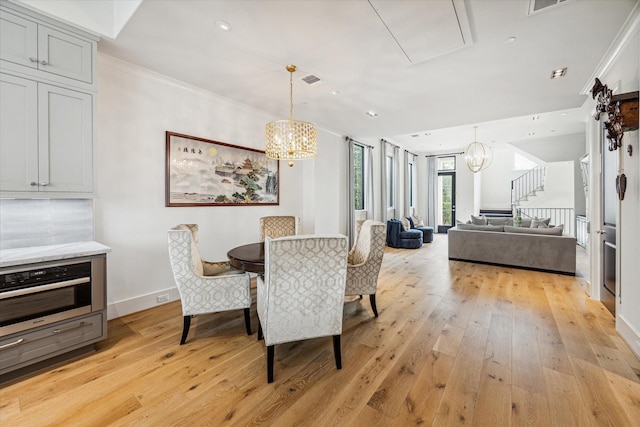 5211 Calle Cordoba Pl, Houston, TX 77007 - dining area with a chandelier, light wood finished floors, baseboards, ornamental molding, and stairway
