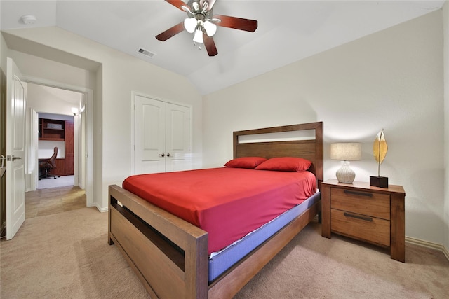 bedroom featuring light colored carpet, vaulted ceiling, a closet, baseboards, and a ceiling fan