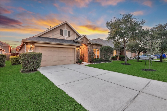 traditional home featuring concrete driveway, brick siding, a yard, and a garage