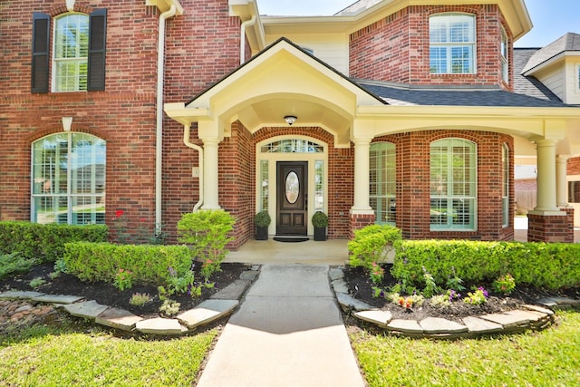 13911 Falcon Heights Dr, Cypress, TX 77429 - view of exterior entry with brick siding, a shingled roof, and covered porch