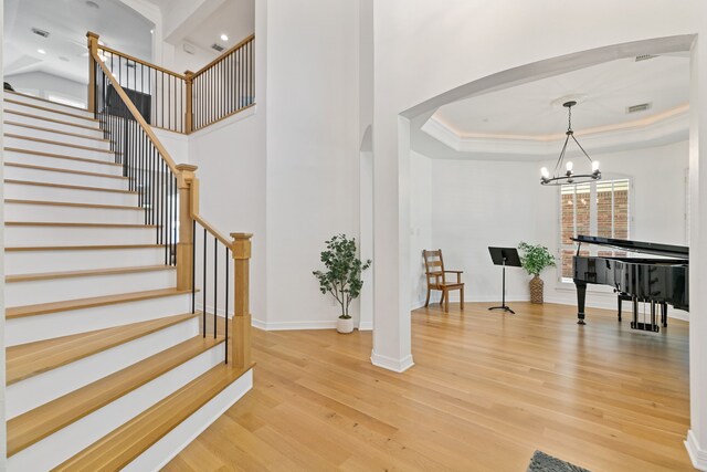 13911 Falcon Heights Dr, Cypress, TX 77429 - foyer entrance featuring light wood-style floors, arched walkways, a chandelier, stairs, and a towering ceiling